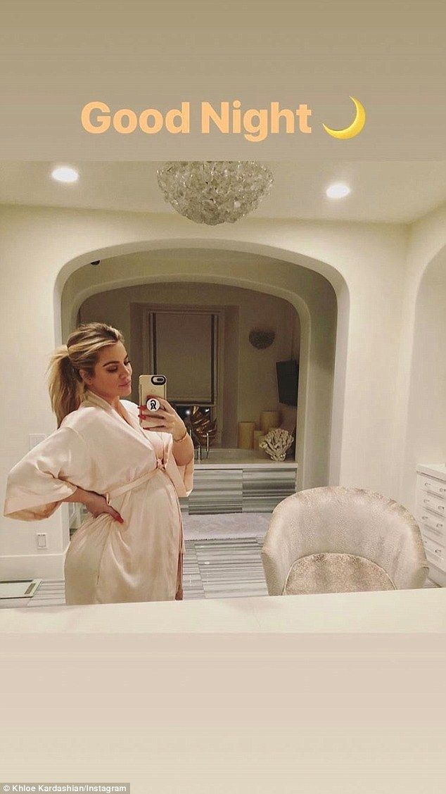 Oh baby: Khloe Kardashian highlights her growing bump as she poses in a robe on ...