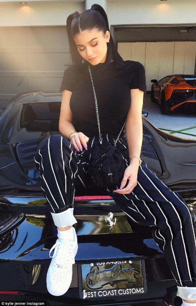 The girlfriend of Travis Scott donned a black T-shirt and baggy black pants with...