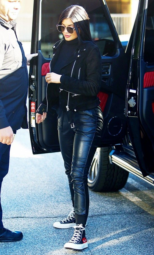 Kylie Jenner wears a turtleneck, suede moto jacket, leather joggers, high-top sn...